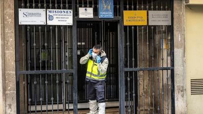 Un gente de la policía científica, el pasado martes, en el portal del edificio de Valencia, donde unas horas antes se había hallado el cadáver del sacerdote Alfonso López.