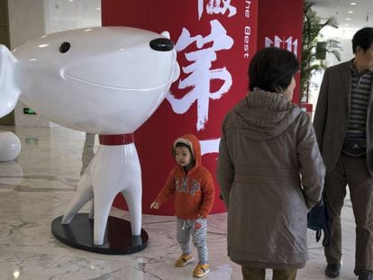 Un nu&ntilde;o pasea junto a la mascota del gigante chino del comercio electr&oacute;nico JD.Com.