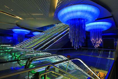 Derroche submarino de luces azules y lámparas de araña con lágrimas de medusas en la parada de Burjuman, en el metro de Dubái.