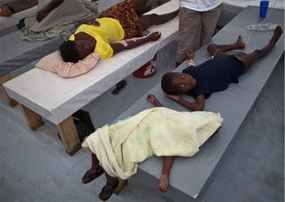 Un niño enfermo de cólera permanece tumbado junto al cadáver de una niña de tres años no identificada en un hospital del barrio de Cité Soleil, en Puerto Príncipe.