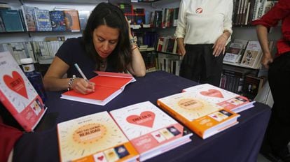 La autora del libro autoeditado 'Cree en ti', Rut Nieves, firma uno de sus ejemplares en la Feria del Libro de Madrid.