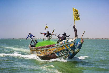 La tripulación de un cayuco de pesca se adentra en el mar tras salir de la desembocadura del río Senegal.