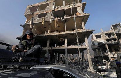 Un soldado del Ejército sirio se fuma un cigarro frente a un edificio en escombros en al-Hajar al-Aswad, el 21 de mayo de 2018. 