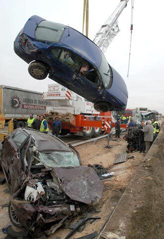 Una grúa retira uno de los coches accidentados, que interrumpía el paso por la autovía.