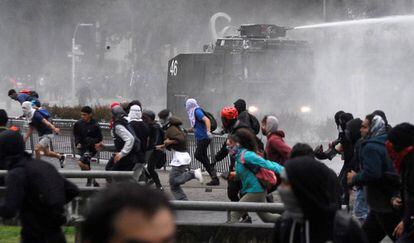 Los manifestantes se enfrentan el lunes a la policía durante una protesta contra el Gobierno de Piñera en Concepción, Chile.