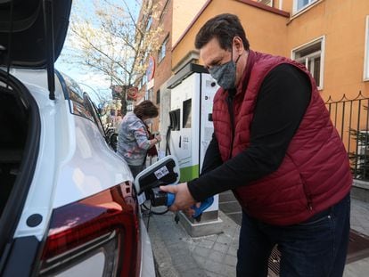 Un usuario recarga su coche eléctrico en un punto situado en la calle en el centro de Madrid.