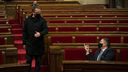 El diputado de la CUP, Vidal Aragones (izq.) conversa con el consejero de Interior, Miquel Sàmper, en el Parlament.