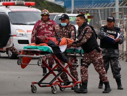 Guardias evacúan a un prisionero herido en el amotinamiento en la cárcel Cotopaxi en Latacunga, Ecuador, el 4 de octubre de 2022.