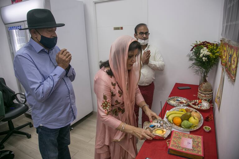 La familia Lalwani, durante el rezo de Diwali en la tienda Desi Gourmet, este sábado.