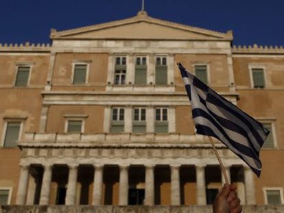 05/07/2016. Un manifestante levanta una bandera de Grecia en una protesta antigobierno en el primer aniversario de las votaciones griegas para un referendo