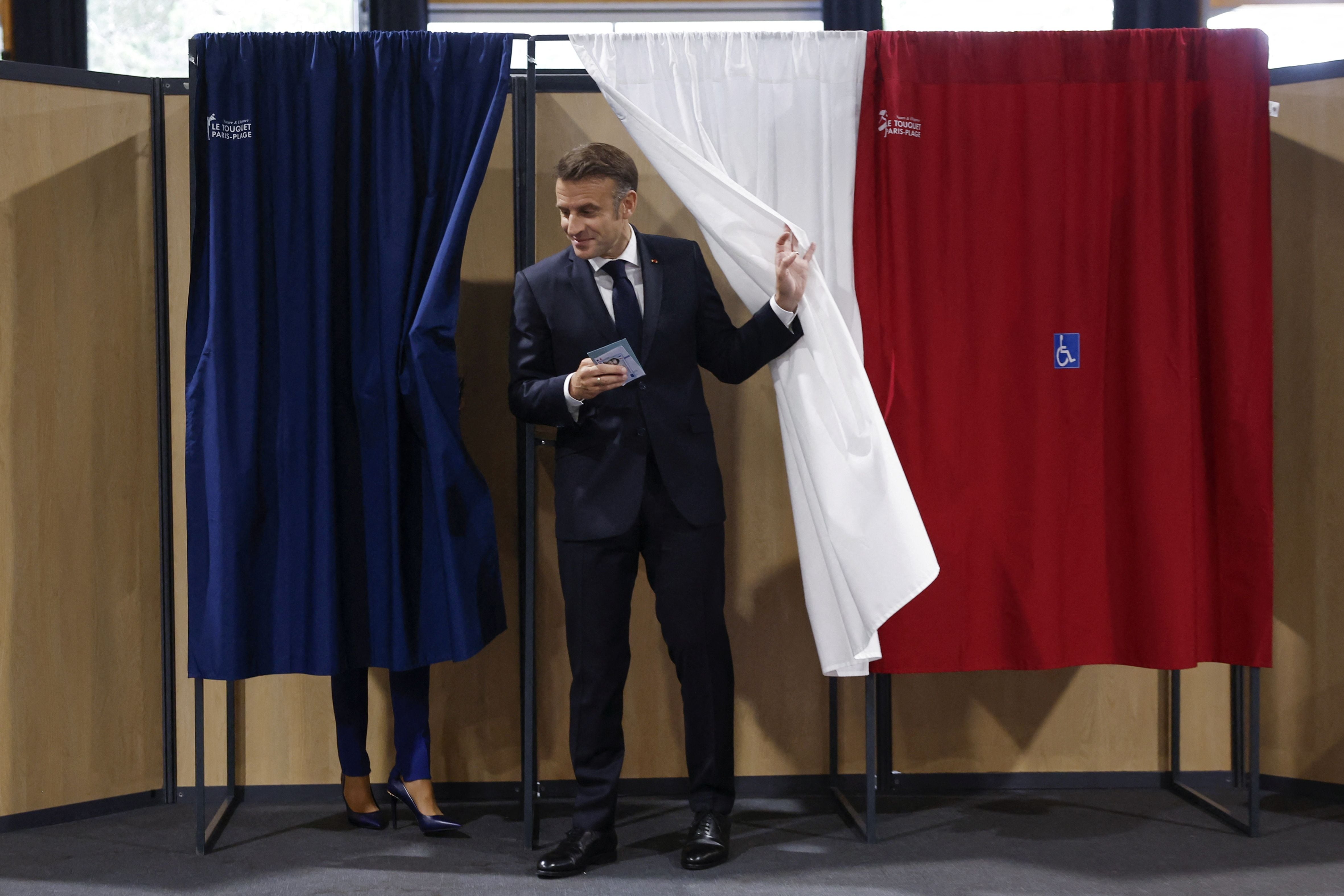 French President Emmanuel Macron (R) and French First Lady Brigitte Macron (L) vote at a polling station in the second round of French parliamentary elections in Le Touquet-Paris-Plage, France, 07 July 2024. MOHAMMED BADRA /Pool via REUTERS