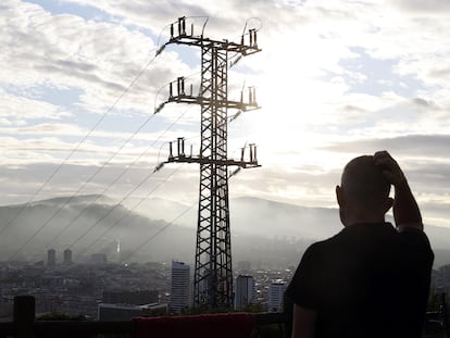 Una persona observa el cableado con el que red eléctrica transporta la energía sobre la ciudad de Bilbao.