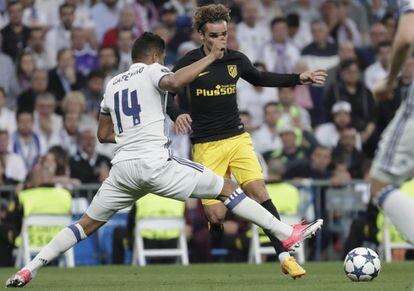 El jugador del Real Madrid Casemiro trata de quitarle la posesión del balón al jugador del Atlético Antoine Griezmann.