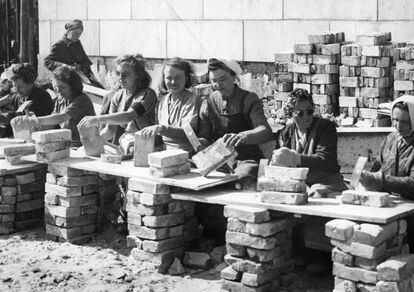 Un grupo de mujeres limpia ladrillos recogidos de los escombros provocados por los bombardeos de la Segunda Guerra Mundial, en 1946 en Berlín. / WALTER GIRCKE (GETTY)