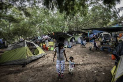 Lucía, una joven madre del Estado mexicano de Guerrero, camina con su pequeña hija por un campamento improvisado de migrantes en Matamoros, en el Estado de Tamaulipas, al norte de México.