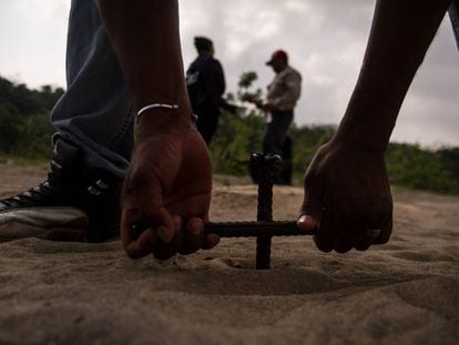 Un hombre entierra una varilla para buscar cuerpos en Colinas de Santa Fe, Veracruz. 