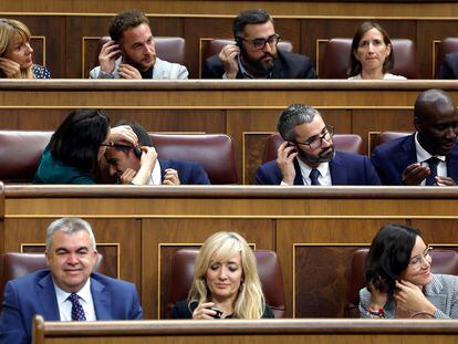 Diputados socialistas se colocan los auriculares de traducción, el día 19 en el Congreso de los Diputados.