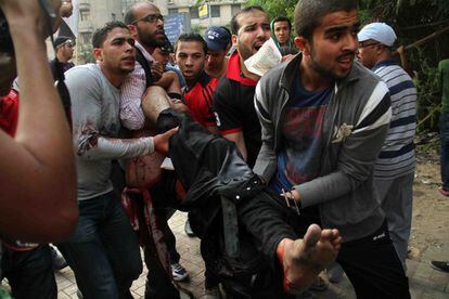 Un grupo de manifestantes evacúa a un herido, víctima de los enfrentamientos con la policía.