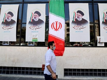 Un hombre pasa ante la oficina de un candidato a las presidenciales del próximo 18 de junio, este lunes en Teherán.