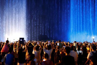 Una multitud de gente graba con sus teléfonos móviles una fuente de agua, en la provincia de Zhejiang (China).