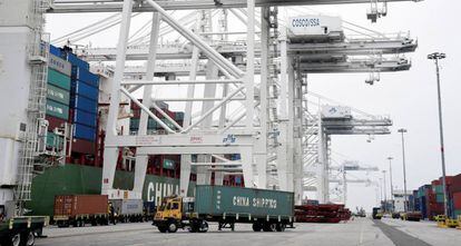 Camiones cargando containers en un barco en el puerto de Long Beach.