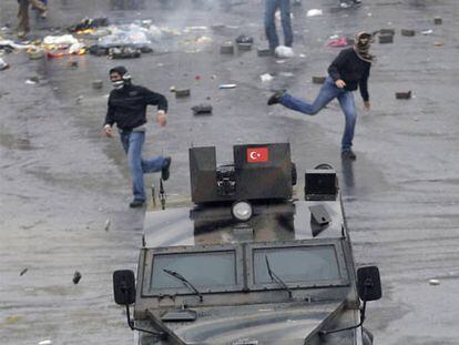 Jóvenes kurdos tiran piedras contra un vehículo policial en Estambul.