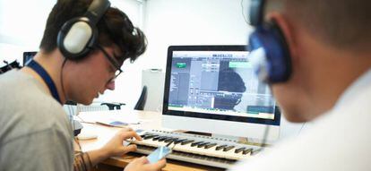 Un profesor de música enseña a su alumno a componer ayudado por las nuevas tecnologías.