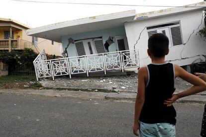 Un niño observa una casa dañada por el terremoto de magnitud 5,8 que sufrió el pasado día 6 la costa de Guánica (Puerto Rico).