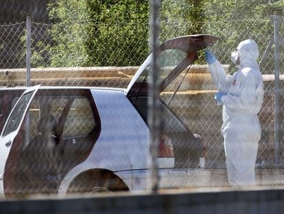 Un agente de la policía científica junto al coche donde se ha encontrado el cadáver de un hombre en la localidad de Roses (Girona), este martes.