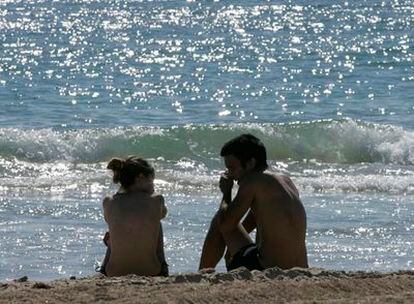 Dos jóvenes, ayer, en la playa de Cortadura, en Cádiz.