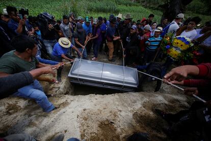 Los familiares del fallecido Pascual Melvin Guachiac, de 13 años, depositan su ataúd en una tumba.