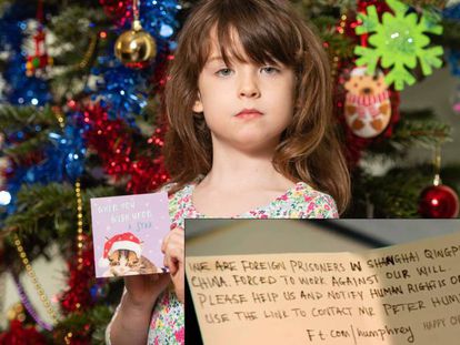 Florence Widdicombe, de seis años, posa con una tarjeta navideña de Tesco como en la que halló un mensaje de un preso extranjero en China, en el que pide que contacte con el experiodista Peter Humphrey.