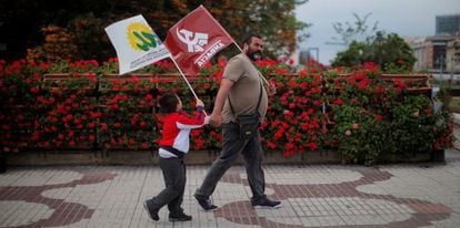 Un simpatizante y su hijo con banderas de IU. 