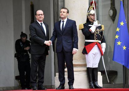 El nuevo presidente francés, Emmanuel Macron, estrecha la mano de su predecesor, François Hollande, tras la ceremonia de toma de posesión en el palacio del Elíseo en París.