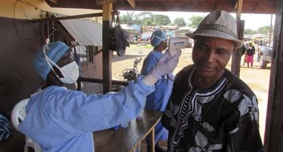 Un sanitario le toma la temperatura a un hombre en Ganta (Liberia).