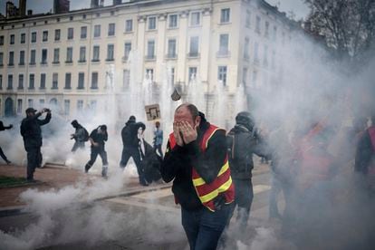Manifestantes corren en medio de los gases lacrimógenos durante una manifestación en Lyon, centro de Francia, este jueves.