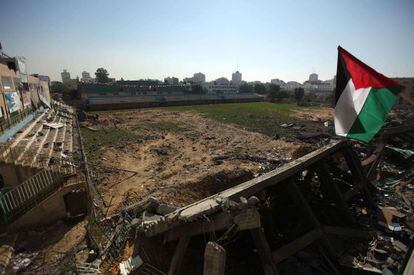 Una bandera palestina entre los restos del estadio de f&uacute;tbol de Gaza.