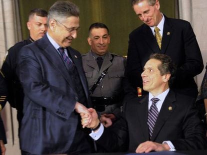 Sheldon Silver, de pie, estrecha la mano del Gobernador de Nueva York, Andrew Cuomo, en un acto de 2013.