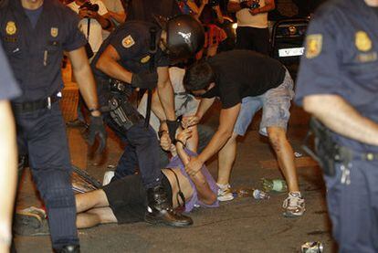 Un policía esposa a uno de los detenidos a primera hora de la noche de ayer en la Puerta del Sol.