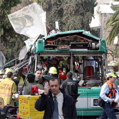 La policía y los servicios de rescate examinan el autobús objeto del atentado.