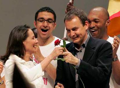 Ségolène Royal entrega una rosa a José Luis Rodríguez Zapatero ayer en el Palacio de Exposiciones de Toulouse.