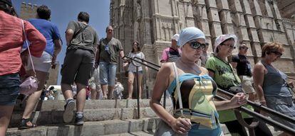 Varios turistas extranjeros visitan la catedral de Palma de Mallorca.