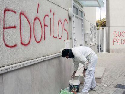 Un pintor cubre una pintada en noviembre de 2014.