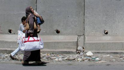 Una palestina y sus hijos caminan por la localidad de Aram.