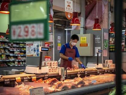 Un comerciante corta la carne en un supermercado en Pekín.