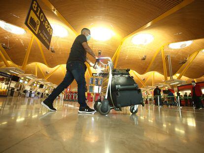 Un hombre camina con varias maletas en un carro en la terminal T4 del Aeropuerto Adolfo Suárez Madrid-Barajas, en Madrid el 15 de marzo.