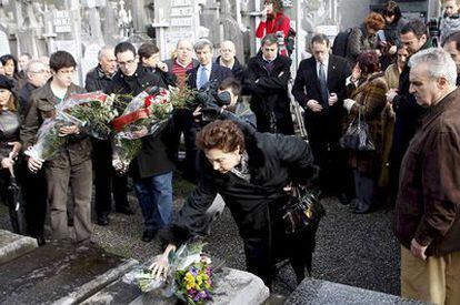 Mapi de las Heras, viuda del político asesinado, coloca un ramo de flores sobre la tumba.