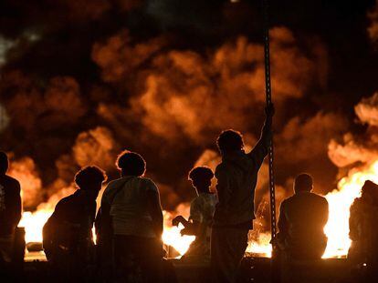 Un grupo de jóvenes junto a una barricada de neumáticos en llamas, este jueves en Burdeos.