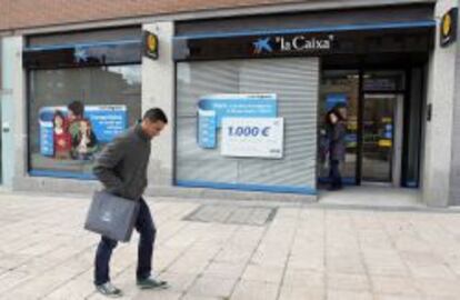 Una sucursal de La Caixa, con una promoción de seguros en su escaparate.