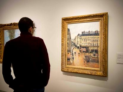 Un visitante observa el cuadro de Camille Pisarro, 'Rue Saint-Honoré por la tarde. Efecto de lluvia', esta mañana en el Thyssen.